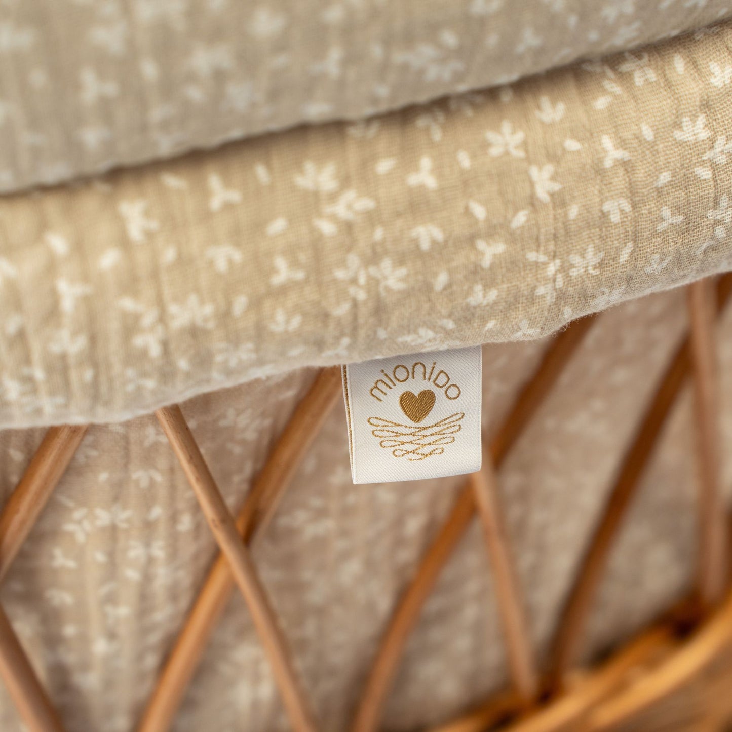 Natural woven Stubenwagen fabric with subtle white floral pattern and tag detail. - Mionido - Bollerwagen Tony (natur)